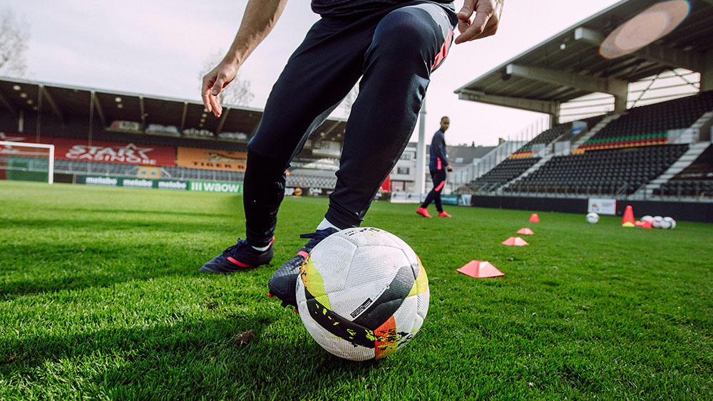Close-up of football player dribbling football